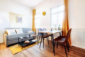 sala de estar con sofá, mesa y sillas en BackHome - Fantastische Schlosslage, SmartTV, Waschtrockner, Netflix, 50qm, 24h Checkin - Apartment 3, en Ludwigsburg