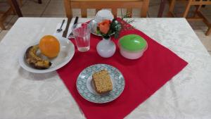 una mesa con un plato de pan y fruta. en Espaço Verona-Apartamento econômico duplo c/banheiro e sem café en Fazenda Rio Grande