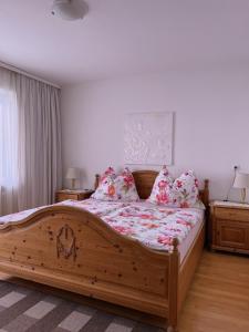 ein Schlafzimmer mit einem großen Holzbett mit Kissen in der Unterkunft B&B Haus Seethaler - Not a hotel ! in Wörgl