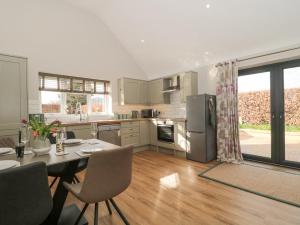 a kitchen with a table and chairs and a refrigerator at Little Haven in Blandford Forum