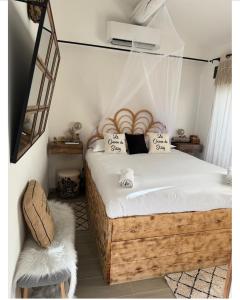 sypialnia z łóżkiem z drewnianą ramą w obiekcie Le cocon de sissy w Saintes-Maries-de-la-Mer