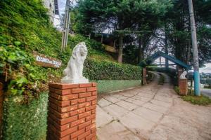 uma estátua de um leão em cima de uma parede de tijolos em Suítes para locação próximo ao Capivari em Campos de Jordão