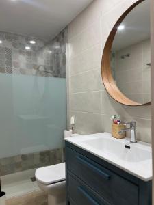 サアラ・デ・ロス・アトゥネスにあるAPARTAMENTO ATLANTERRA PLAYA PRIMERA LINEAの洗面台、鏡、トイレ付きのバスルーム