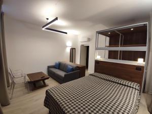 een slaapkamer met een bed, een bank en een stoel bij Residence Al Granzo in Trieste