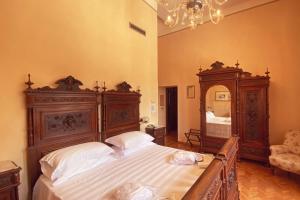 Hotel Villa Quiete في Montecassiano: غرفة نوم مع سرير خشبي كبير ومرآة