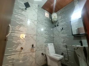 La salle de bains est pourvue de toilettes et d'un lavabo. dans l'établissement Ramandeep Stays, à Dharamshala