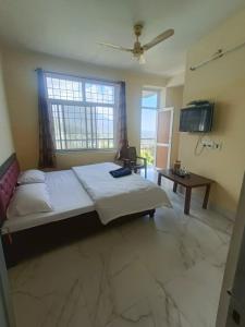 - une chambre avec un grand lit et une télévision dans l'établissement Ramandeep Stays, à Dharamshala