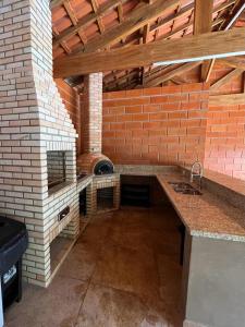 uma cozinha exterior com uma parede de tijolos e um forno em Rancho Quedasdagua em Itu