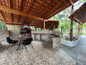 een patio met een tafel en een open haard bij Rancho Quedasdagua in Itu