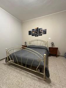 1 dormitorio con cama de metal y 2 cuadros en la pared en Dimora Gaudiano, en Matera
