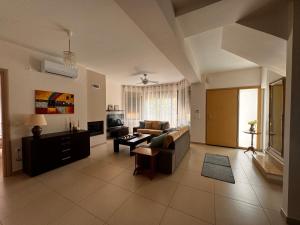 uma sala de estar com um sofá e uma mesa em Porto Rafti Holiday Apartment em Porto Rafti