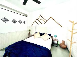 a bedroom with a large bed with blue sheets at Nandi Private Residence, Bohemian Hill View Villa in Devanahalli-Bangalore