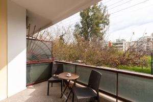 een kleine tafel en stoelen op een balkon met uitzicht bij Comfy flat near Edem Beach By AthenianKeys in Athene