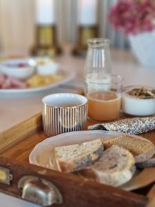 a table with a tray with bread and other foods at Ronehamn Bed and Breakfast in Hemse