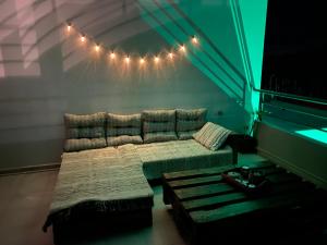 um quarto com uma cama e um sofá com luzes em Marvinas seaside apartments, Earth apartment & Ocean jacuzzi apartment em Kremasti