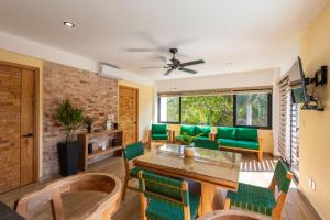 Una sala de estar con una mesa y sillas verdes. en Condominios Brisas del Mar, en Santa Cruz Huatulco