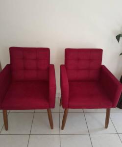 duas cadeiras vermelhas sentadas ao lado uma da outra em Residence Sonho Azul em Salvador