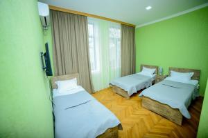 2 camas en una habitación con paredes verdes en Hotel Samta en Tsqaltubo