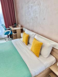 a bed with yellow and white pillows in a room at Rio Apart Deluxe in Sofia +42 photos