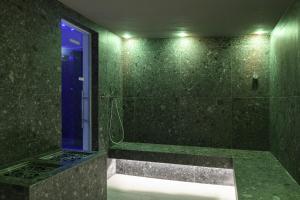a green bathroom with a shower with a blue door at Resort La Battigia Beach & Spa in Alcamo Marina