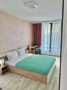 a bedroom with a bed and a desk and a window at Rio Apart Deluxe in Sofia