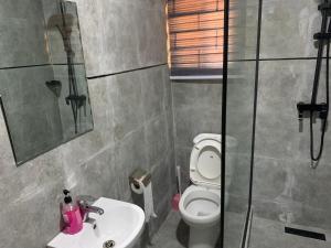 a bathroom with a toilet and a sink and a shower at Adel’s Place in Abuja