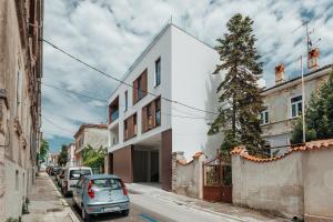 Un pequeño coche aparcado delante de un edificio blanco. en Puntino, en Pula
