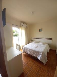 1 dormitorio con cama blanca y ventana en Hotel Schreiber, en Rio do Sul