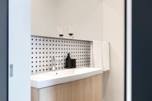 Un baño con un lavabo blanco y una pared de azulejos negros. en Puntino, en Pula 48 fotos más