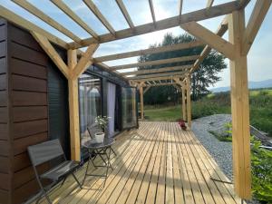 una terrazza in legno con pergolato e tavolo di Tiny House with Mountain Views a Turany Altre 6 foto