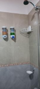 baño con ducha con 2 tazas en la pared en El Cardiel en Gobernador Gregores