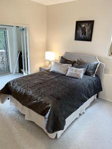 a bedroom with a large bed with a black comforter at Waterfront Eagle Nest in Nanaimo