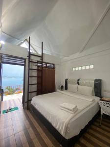 a bedroom with a large bed and a balcony at Vandu's View Guest house & Restaurant in Tuk Tuk