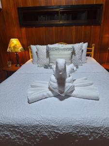 a bed with white towels on top of it at Casona Rústica & Bungalow in Fortuna