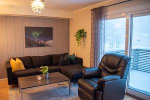 a living room with a couch and a table at Senja, 2 BR apartment, surrounded by the northern lights and the midnight sun in Finnsnes