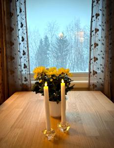 due candele su un tavolo di fronte a una finestra di Senja, 2 BR apartment, surrounded by the northern lights and the midnight sun a Finnsnes