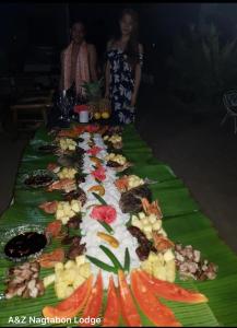 une longue table de nourriture sur une couverture verte dans l'établissement A&Z Nagtabon Lodge, à Bacungan