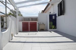 ポルト・オッティオルにあるCasa Vacanze Porto Ottioluの赤いドアと中庭のある白い家
