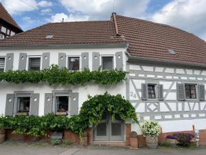 ein weißes Haus mit rotem Dach in der Unterkunft Ferienwohnung Sambachhaus in Gleiszellen-Gleishorbach