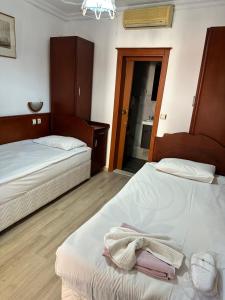 a room with two beds and a bathroom with a mirror at Hotel Karyatit Kaleici in Antalya