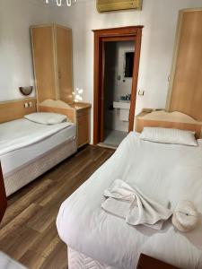een slaapkamer met 2 bedden en een badkamer bij Hotel Karyatit Kaleici in Antalya