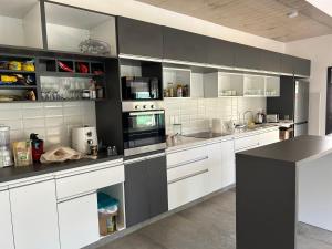 eine Küche mit weißen Schränken und schwarzen Arbeitsplatten in der Unterkunft Excepcional Casa en Solanas Resort in Punta del Este