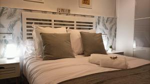 Una cama con sábanas blancas y almohadas en un dormitorio en Zarraci La Guía en Gijón