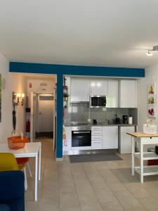 uma cozinha com armários brancos e uma parede azul em Bayview Apartment 213 em Albufeira