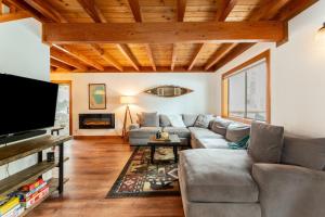 sala de estar con sofá y TV en Indigo Owl by AvantStay Cabin w Hot Tub Firepit Minutes to Lake Slopes, en Homewood