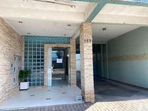 eine offene Tür zu einem Gebäude mit Ziegelwand in der Unterkunft Espaço Verona-Apartamento triplo com banheiro e sem café in Fazenda Rio Grande