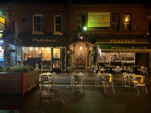 a restaurant with tables and chairs outside at night at Two bed flat in popular York Rd in Birmingham