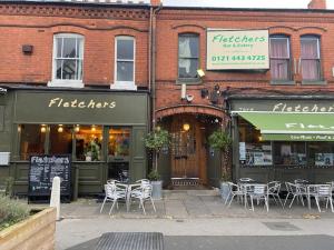 un edificio con mesas y sillas frente a una tienda en Two bed flat in popular York Rd, en Birmingham