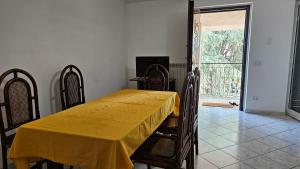 a dining room with a yellow table and chairs at Compatri House in Osteria dellʼ Osa