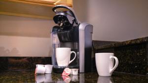 a coffee maker and cups on a kitchen counter at NEW-The Villas-Pool-BBQ-Casino-Colosseum-Beach-Tennis Courts in Biloxi